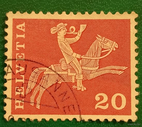 Швейцария 10 мая 1960. Почтальон верхом на лошади трубящий в почтовый рожок