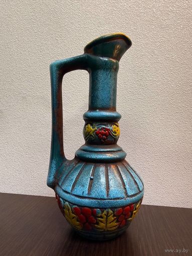 Винтажный керамический кувшин, украшенный рельефным узором из виноградных гроздьев и листьев.