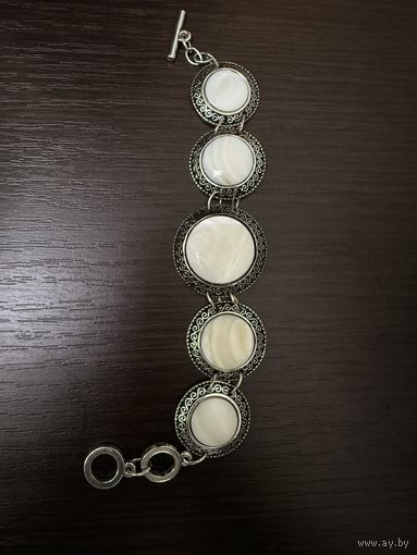 Браслет с вставками из белого перламутра в металлической оправе .